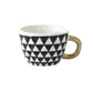 Tasse mit abstraktem geometrischem Muster und goldenem Henkel